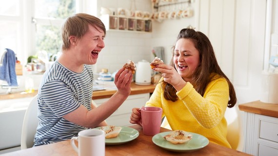 Two young people sat round a table.