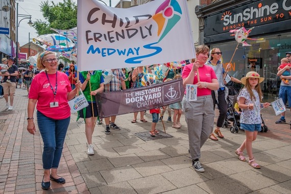 Child-Friendly Medway team walking with our flag in the Chatham Carnival Parade. 