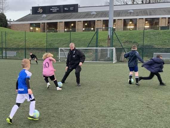 Kent Police Officer playing football with young people at our Drop-In Football at Strood Sports Centre. 