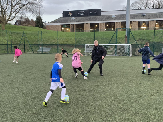 Kent Police Officer playing football with young people at our Drop-In Football at Strood Sports Centre.