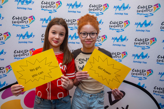 Two girls holding quotes as part of an inspirational quote photo opportunity at our International Womens Day Celebration 'Girls' Just Wanna' Have Fun'