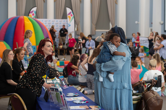 Parent/carer talking to a partner at the Baby and Toddler Week event. 