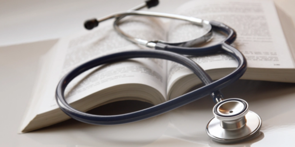 A doctor's stethoscope on top of an open book