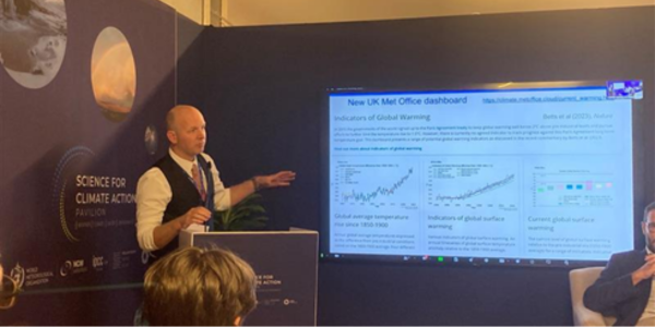 A Met Office scientist giving a presentation at COP28
