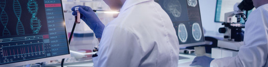 Scientists examines DNA models in modern Neurological Research Laboratory.-medium