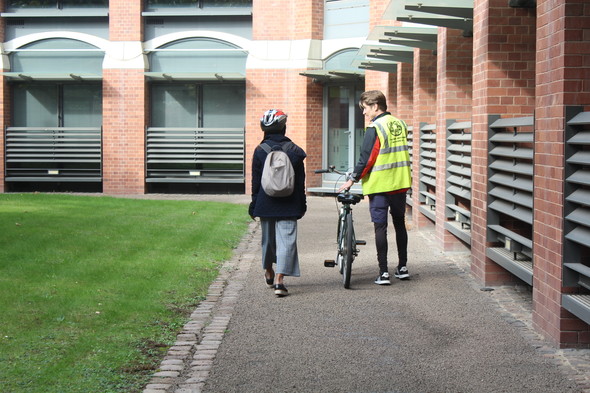 Learner cyclist walking with cycling trainer 