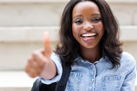 Young female sticking her thumb up and smiling 