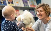 storytelling showing a teddy bear to a toddler