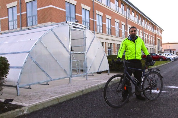 Experian cycle shelter with man standing in front with bike 