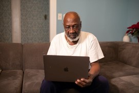 Elderly man looking at laptop