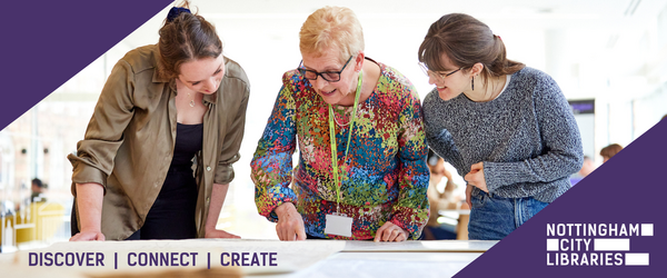 November Header - Three women looking over local studies maps