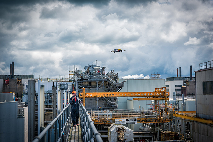 High view of Sellafield site with a drone flying and worker controlling it.