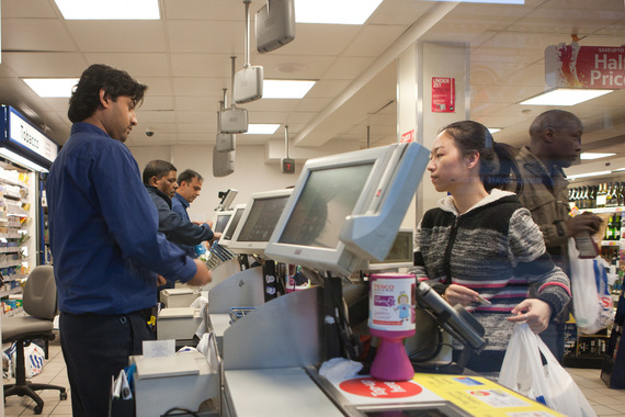 Store assistants working checkout (Tesco)