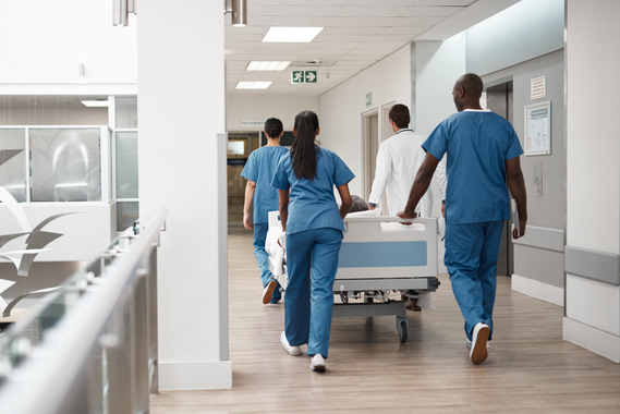 hospital porters wheeling patient in bed