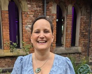 Picture of a lady in front of a red brick building