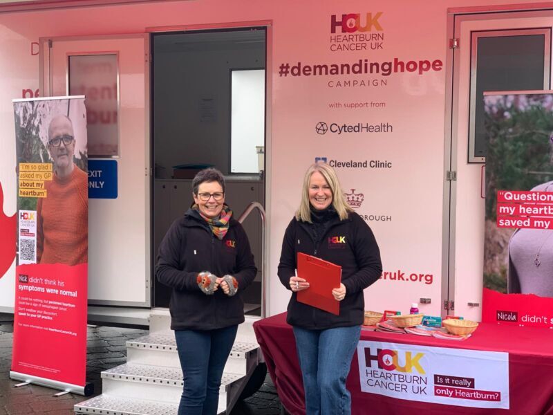 Two women standing in front of a table with leaflets