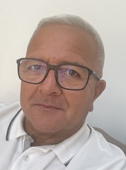 Picture of a man taking a selfie as he is wearing glasses with a white polo shirt