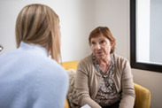 An older white woman talks to a counsellor