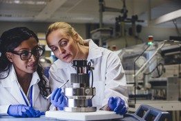 Two female scientists looking at medical lab equipment