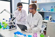 Male and female researchers reviewing paperwork in a lab