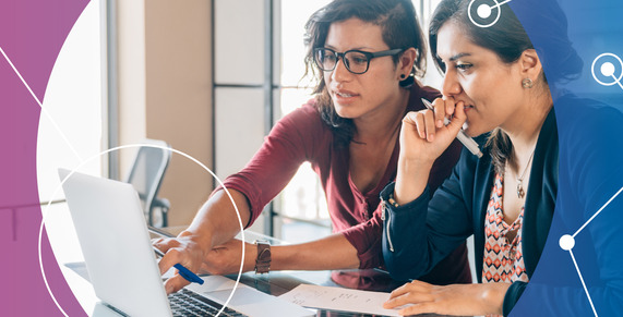 Two people looking at a laptop and making notes