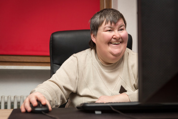 A photo of a person sitting at a desktop PC using the mouse and keyboard.