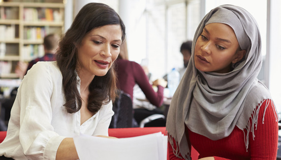Two people working together, looking at a laptop