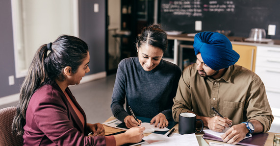 People collaborating on a project, sitting around a desk