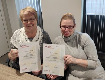 Eve on the left and Di on the right holding their Parent Champion certificates