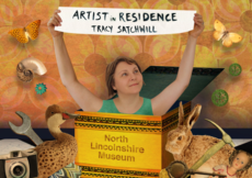 Image of artist Tracy Satchwill holding a banner that says Artist in Residence
