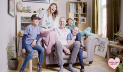 Photograph of parents and adopted children on a sofa
