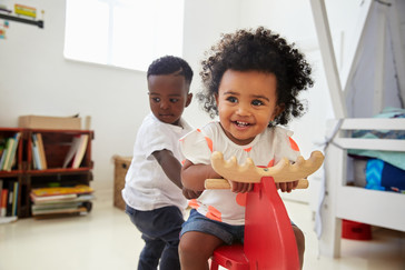 Two toddlers playing on ride on toys 