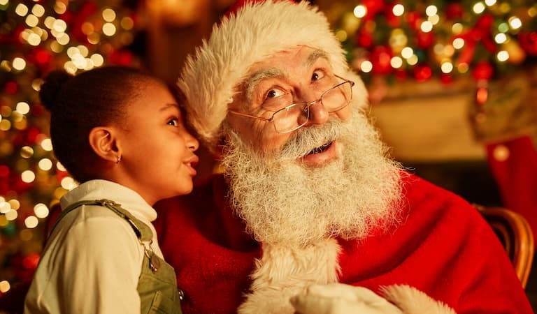 Young girl whispering to Santa 