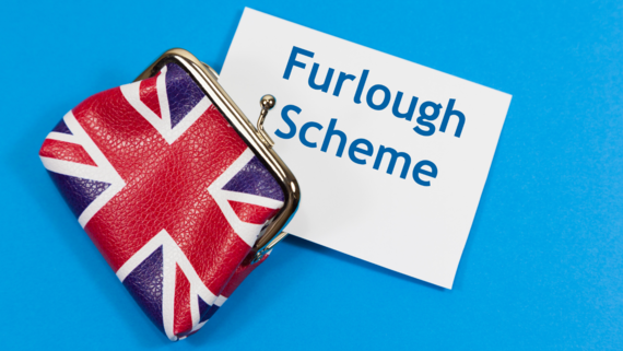 Union jack purse with a piece of paper saying 'furlough scheme coming out of it