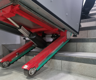 An Electric Stair Climbing Machine carrying a vending machine up some steps