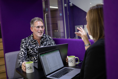 Tick HR Solutions staff sat across from each other at a desk