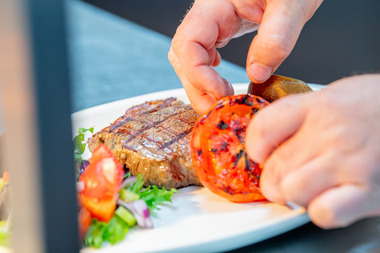 A chef serving a plate of food