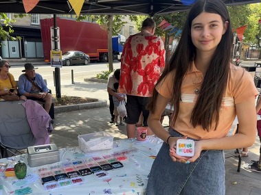 Teen trader holding up their custom designed press-on nails
