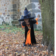 Young girl in witch costume in the woods
