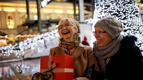 Two women laughing while Christmas shopping
