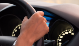 Hand on car steering wheel
