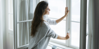 A woman opening a window at home