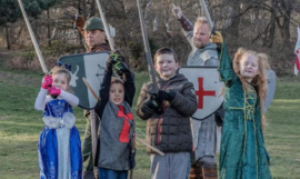 Children dressed in medieval clothes holding swords