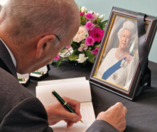 Sir John Peace signing the book of condolence