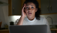 Anxious looking woman sitting in front of a laptop
