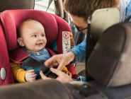 A baby being strapped into a car seat