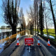 Road closure signs on flooded road