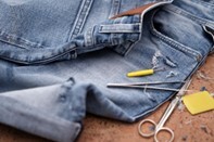 Close up of a pair of jeans and sewing items