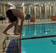 A swimmer taking a dive to begin a race