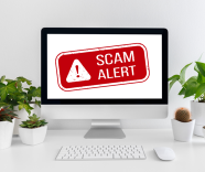 Photo of a computer with a scam alert icon on the screen